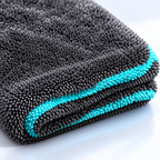 AI-assisted illustrative close-up of charcoal loop-pile towel fabric and turquoise detailing