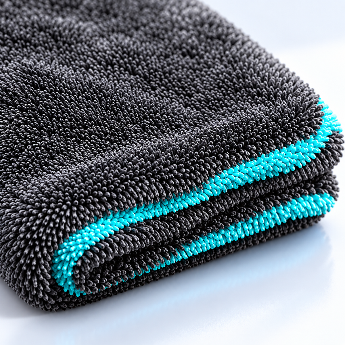 AI-assisted illustrative close-up of charcoal loop-pile towel fabric and turquoise detailing